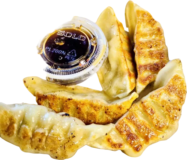 Pan-seared chicken pot stickers with a cup of dipping sauce